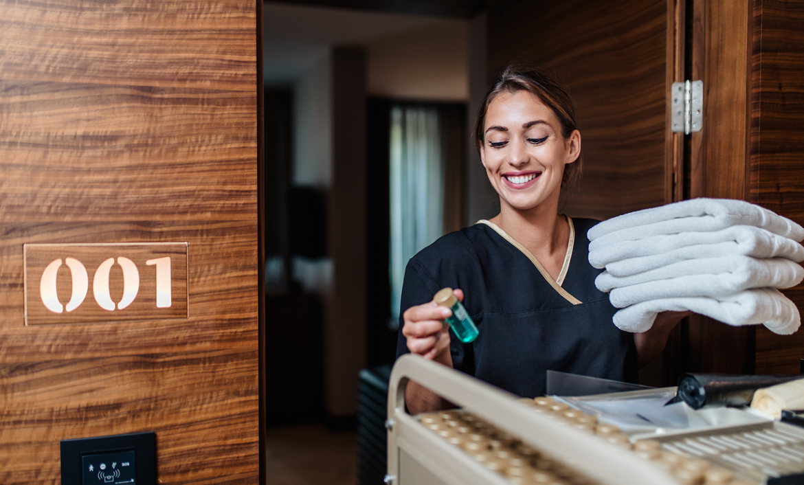 Hotel housekeeping staff delivering clean towels and amenities to a guest room