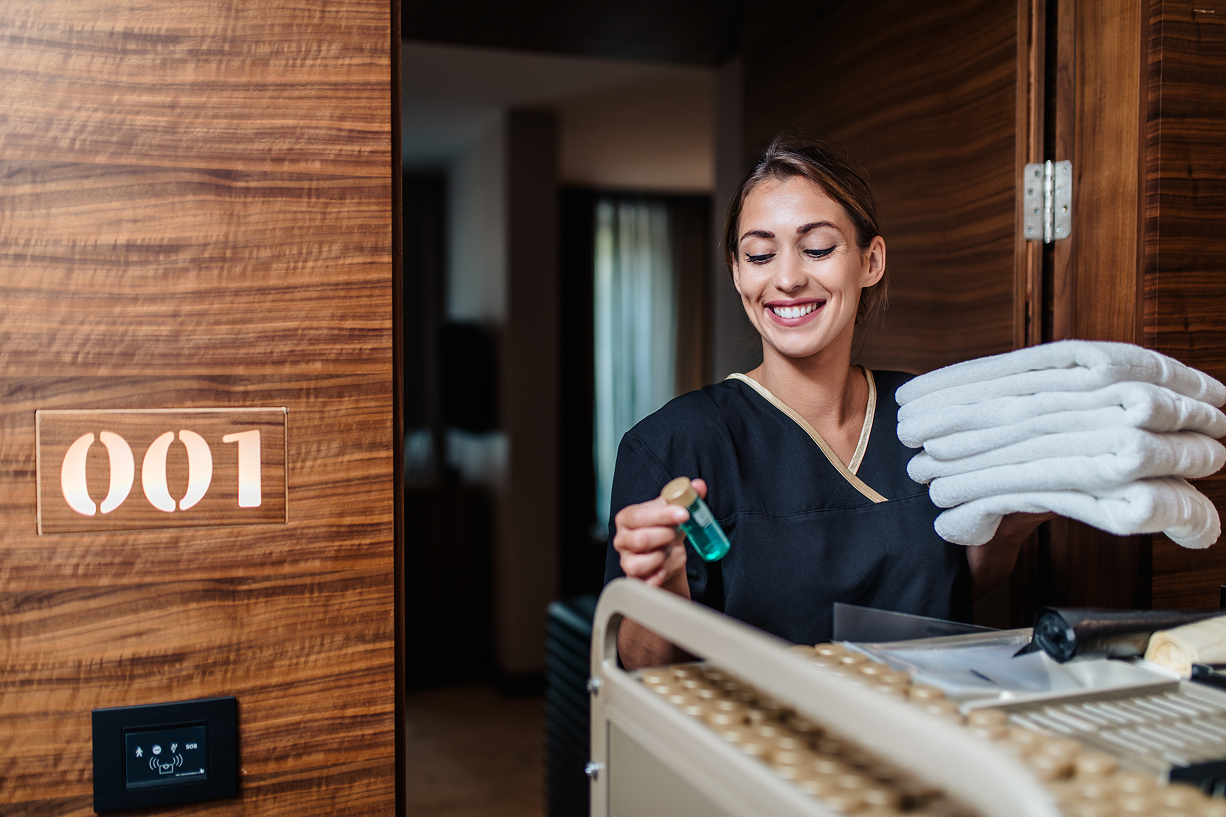 Hotel housekeeping staff delivering clean towels and amenities to a guest room