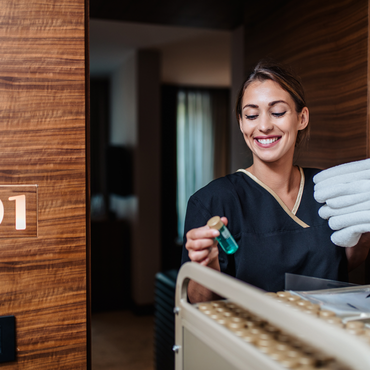 Hotel housekeeping staff delivering clean towels and amenities to a guest room
